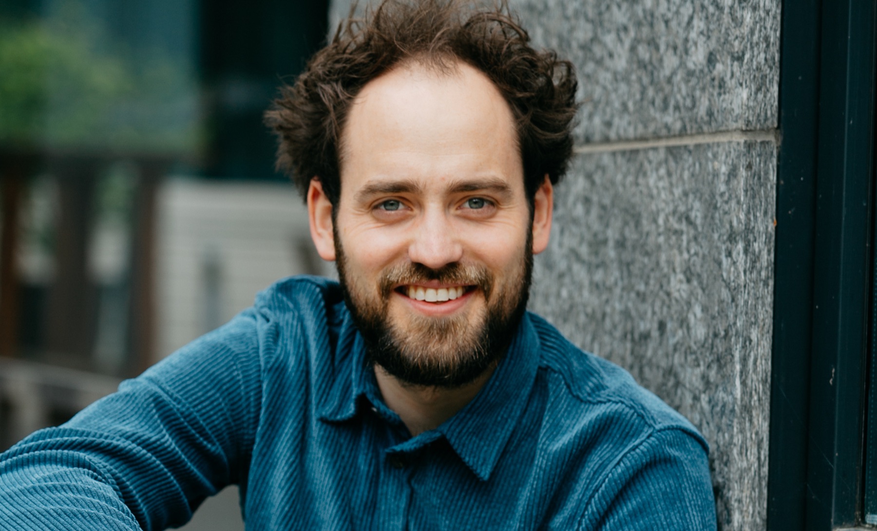 Josua Laufer lächelnd im blauen Hemd